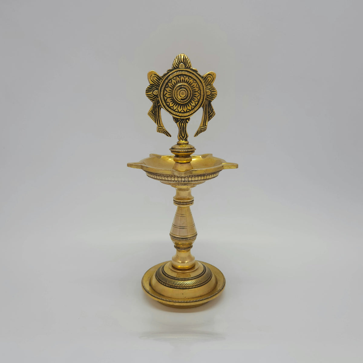 Front presentation view displaying the matching pair of 25cm brass Shanku and Chakra standing kuthu vilakkus side-by-side on a white background.