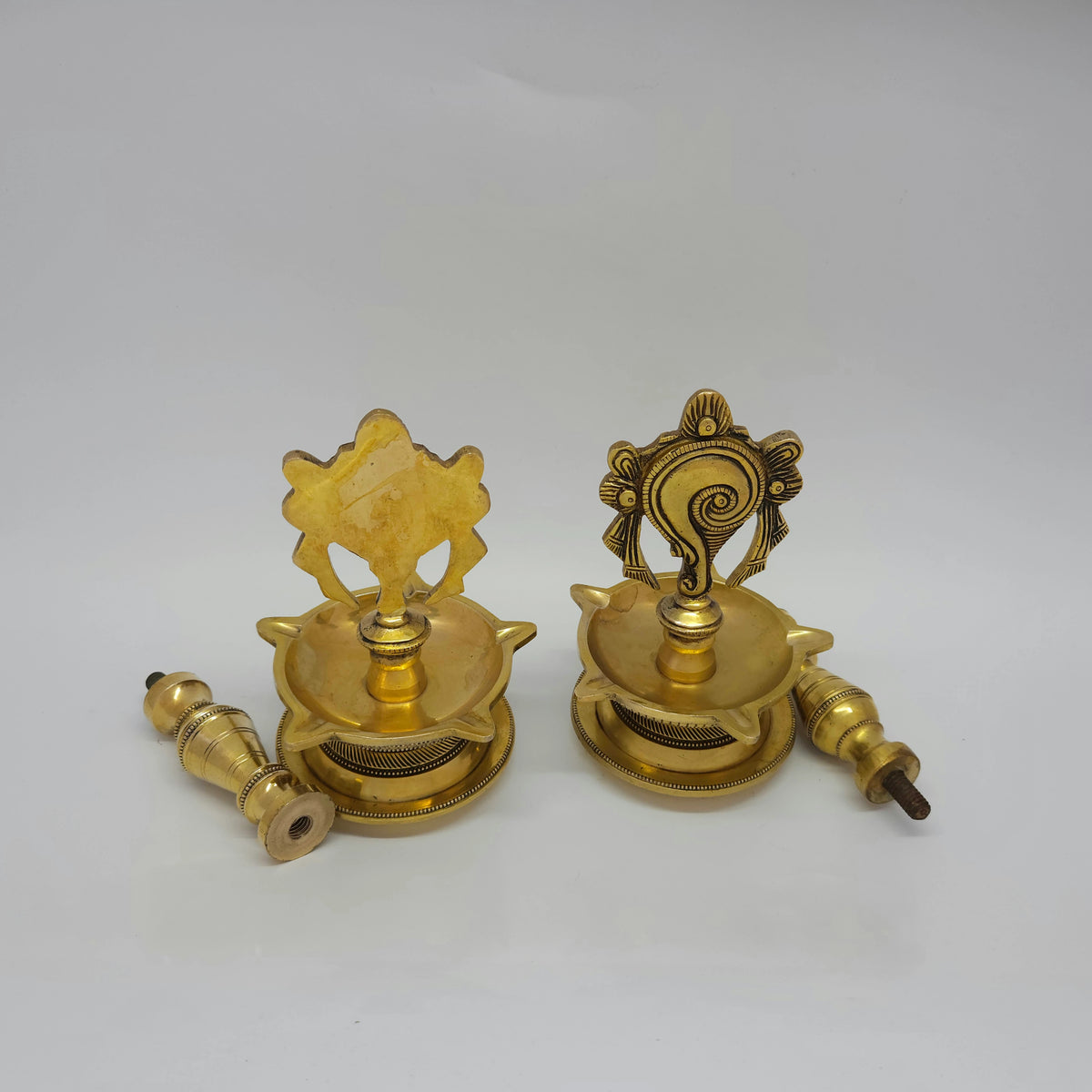 Rear presentation view of the 25cm brass Shanku and Chakra standing lamps showcasing the clean high-gloss mirror finish along the base plates.