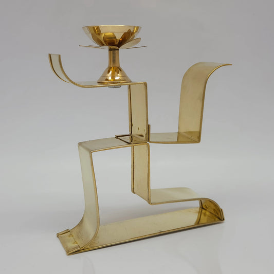 Side angle photo of pure brass Swastik shape pooja deepam showing the thickness and golden metal finish.