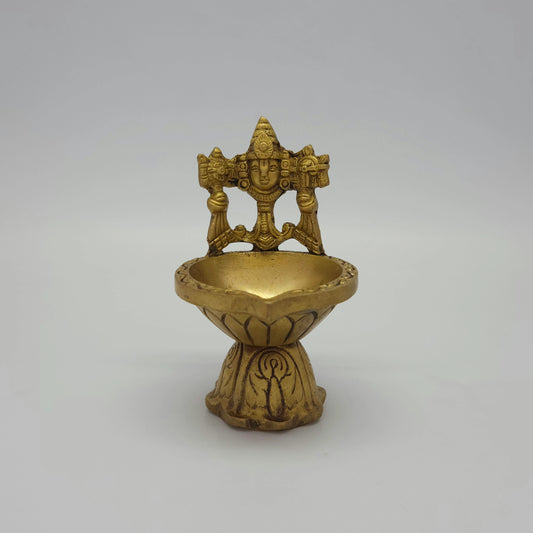 Front view of a 5 inch solid brass antique finish Perumal vilakku by Sri Swaminathan and Co Kumbakonam showing the shanku, chakra, and deep oil bowl against a clean light grey background.