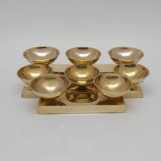  Front view of a pure glossy brass triple cup and dual cup altar stand securely fixed onto a solid rectangular base plate with comparison