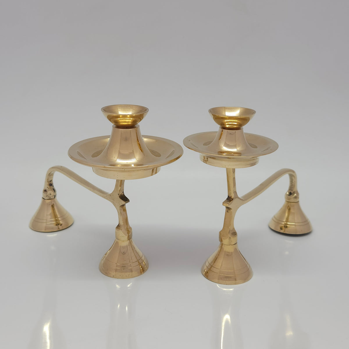 Front perspective view of small and big size  of two-tier pure brass camphor arati stands showing the scalloped edges of the lower storage plates