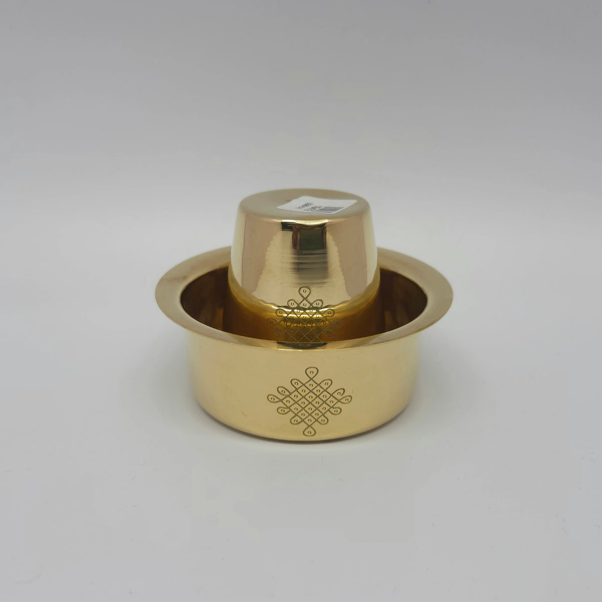 Front view of the traditional brass filter coffee set showing the tumbler inverted inside the 150ml davara basin to display the glossy side engravings.