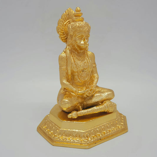 Three-quarter front left perspective view of the eighteen point five centimeter gold coated meditating Hanuman statue highlighting the rested mace weapon.