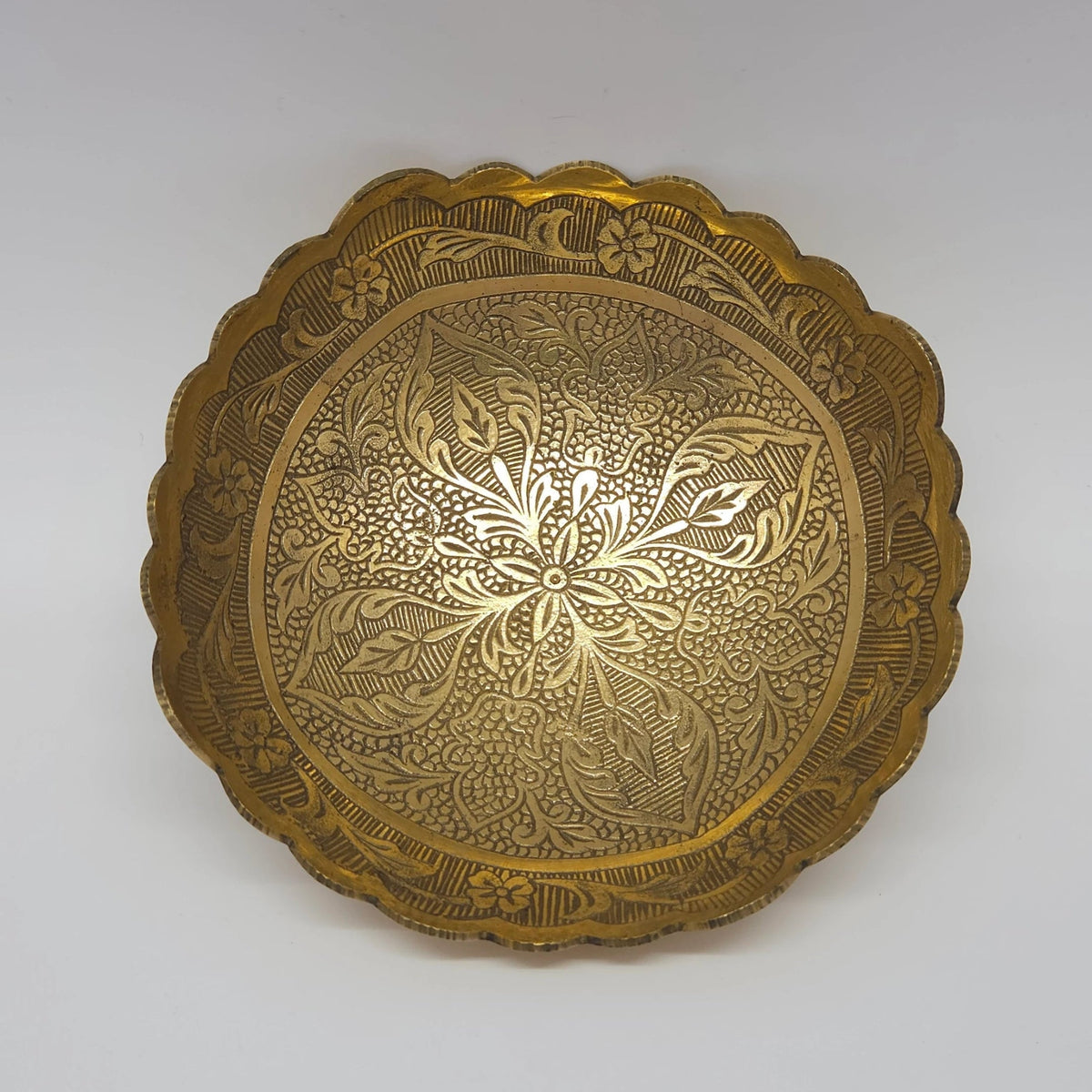 Straight top down view of the 15cm brass bowl highlighting the crisp engraved six-petal center star and continuous leaf vines