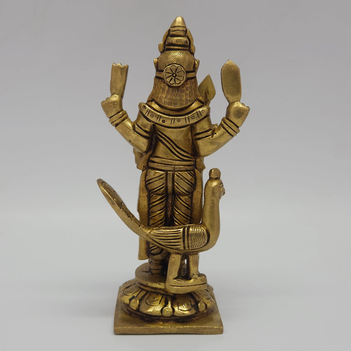 Direct straight back view of the fifteen point five centimeter solid brass Senthil Andavar statue demonstrating the smooth rear finish of his hair and base contours
