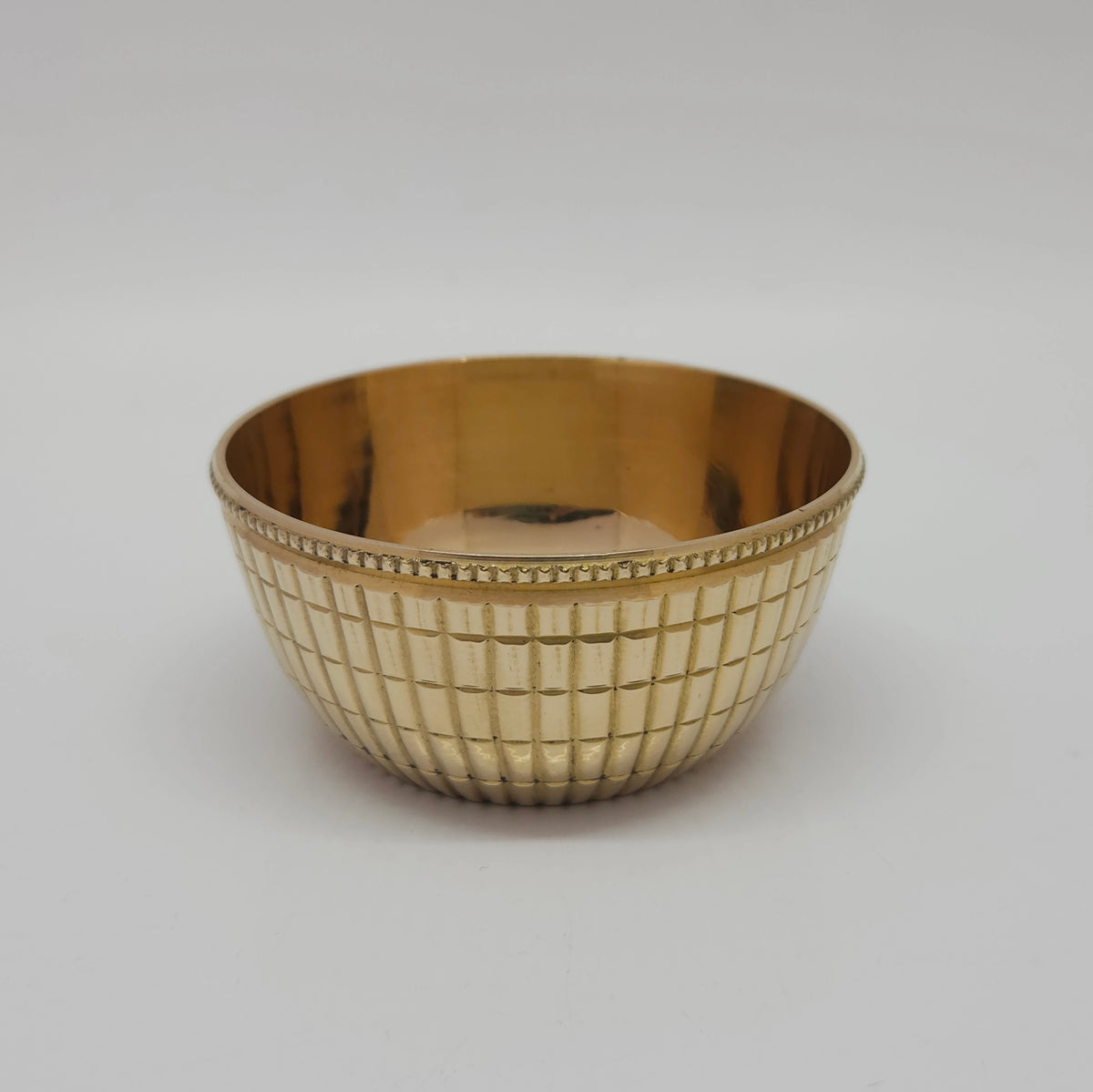 Straight front profile view of the fifty milliliter small brass checked pattern katori cup showcasing the clear texture lines and stepped circular base platform