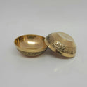 Angled view displaying one floral engraved brass agal vilakku standing upright next to another diya tilted back to reveal the clean 3.4cm flat-bottom layout.