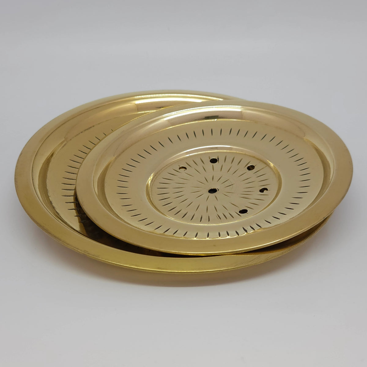 Three-quarter angled perspective view of the fourteen centimeter brass rice strainer lid highlighting the nested stepped rim contours and golden glossy luster.