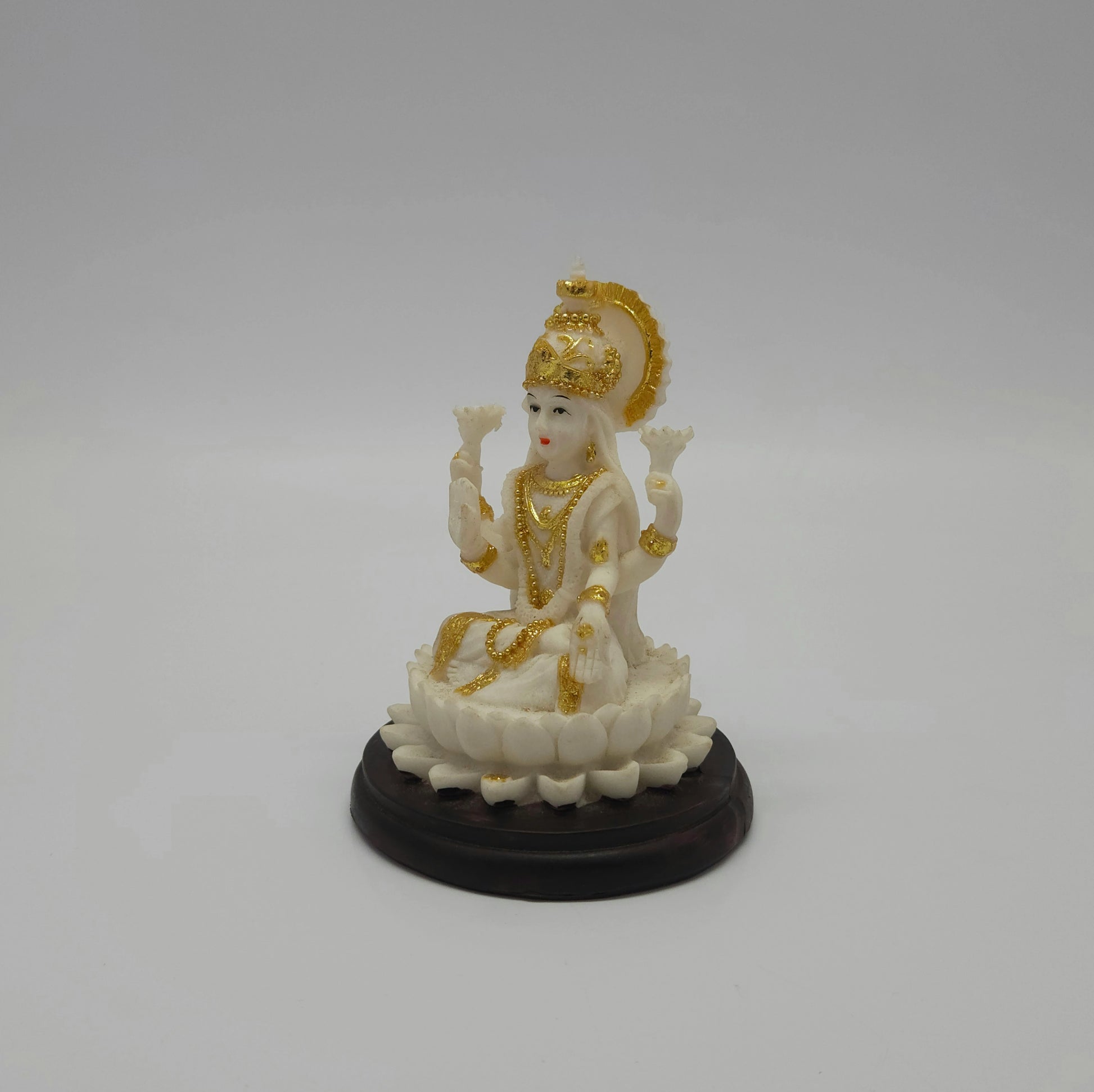 Angled front right view of the white poly-marble Lakshmi figurine showcasing her hand-painted gold crown and detailed clothing folds.