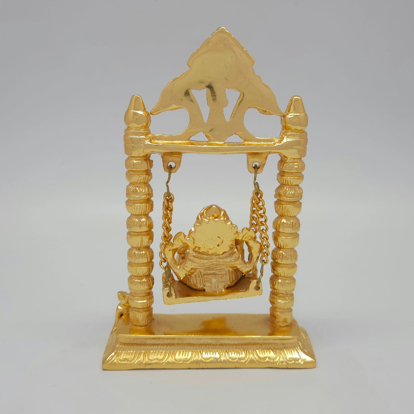 Full back view of the 7.5 inch gold powder-coated solid brass Ganesha on a swing demonstrating the clean contours of the archway backing.