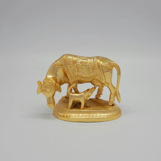 Front view of a premium gold powder-coated brass Kamadhenu cow and feeding calf statue showcasing the sacred Om symbol carved onto the base plate by Sri Swaminathan and Co.
