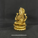 Three-quarter front right perspective view of the two and a half inch brass seated Lakshmi statue showcasing the detailed crown and the open palm with the distinct Om symbol.