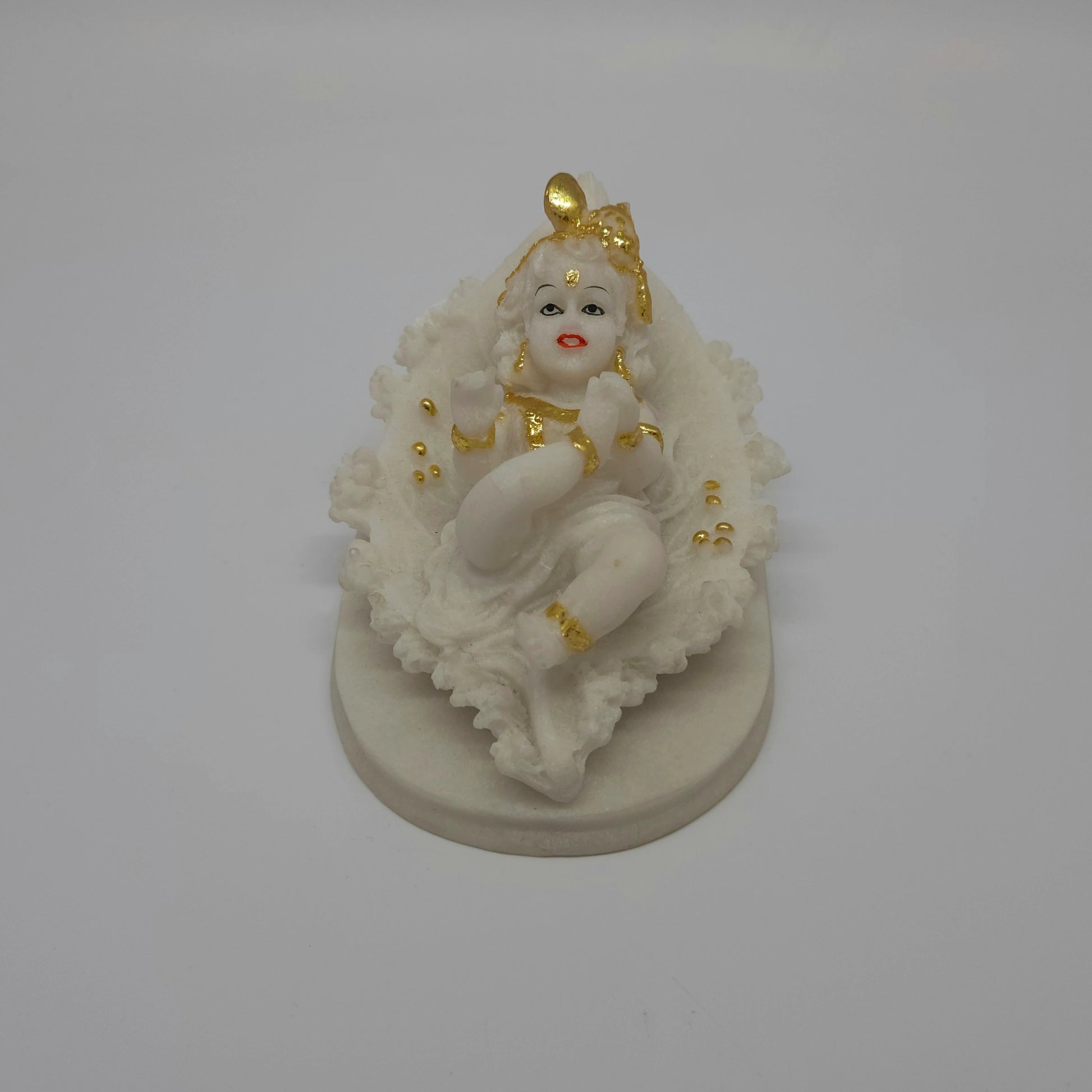 Top-down front view of the independent white resin child Krishna figurine showcasing his peaceful hand-painted facial features.