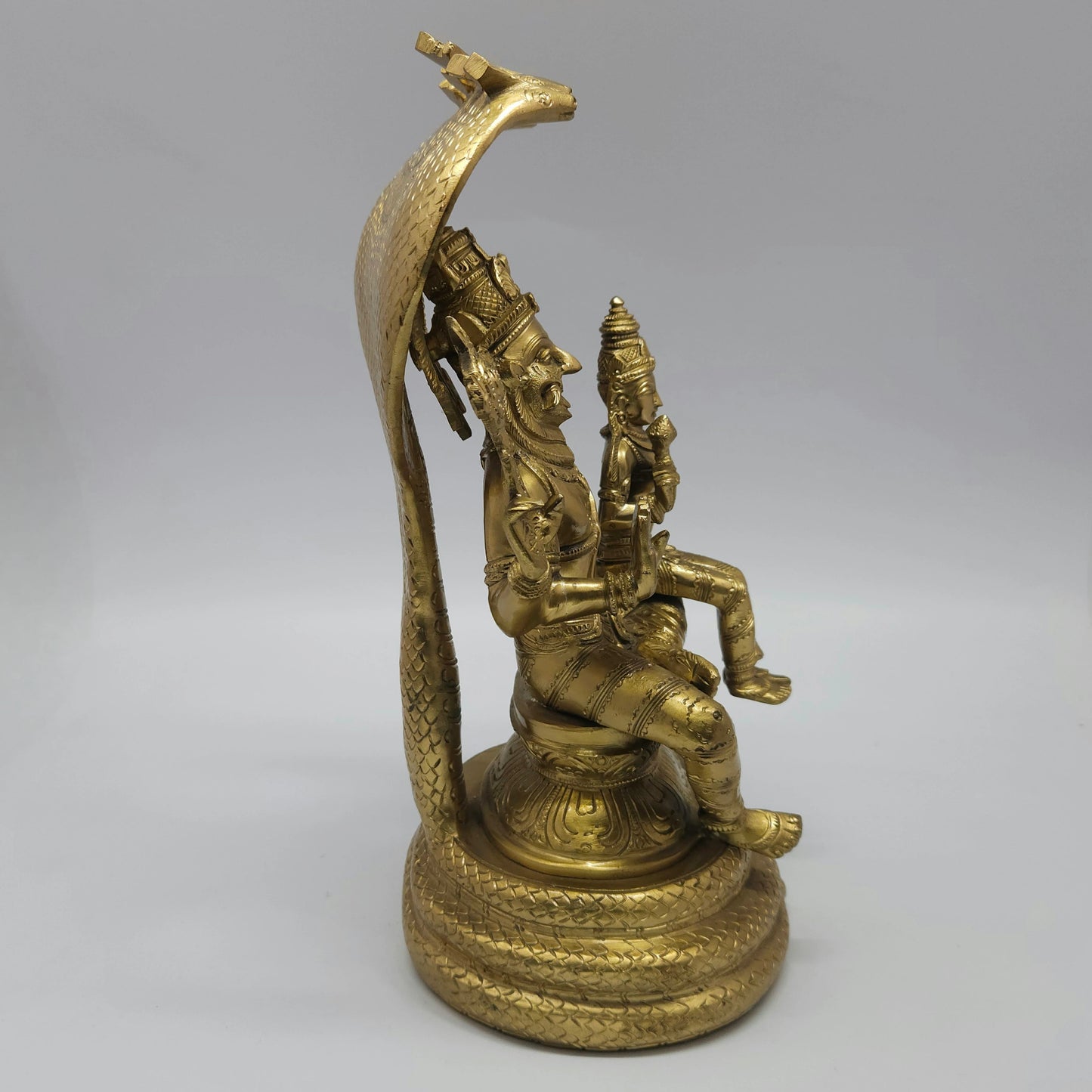 Right side profile of the 11.8 inch solid cast brass Lakshmi Narasimha Swamy figurine displaying the elegant curve of the multi-hooded snake canopy