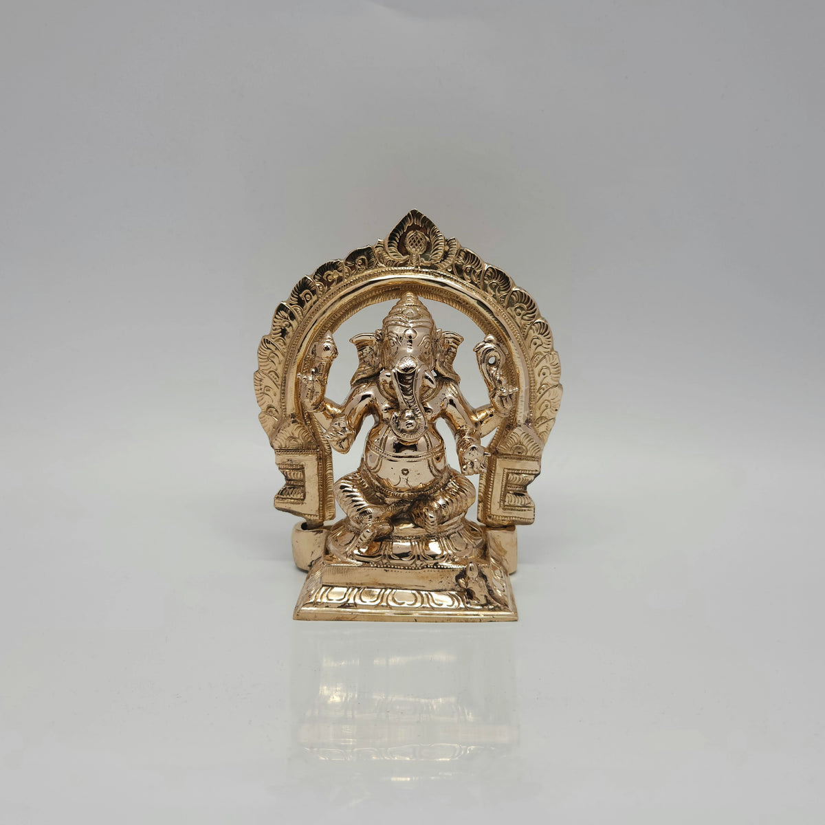 Front view of a 16cm handmade raw Kumbakonam Panchaloha Lord Ganesha statue sitting with its attached Tiruvatchi temple arch by Sri Swaminathan and Co.