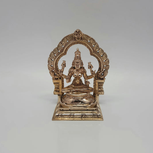 Front view of a 13cm handmade raw Kumbakonam Panchaloha Goddess Lakshmi statue sitting inside a traditional temple arch by Sri Swaminathan and Co.