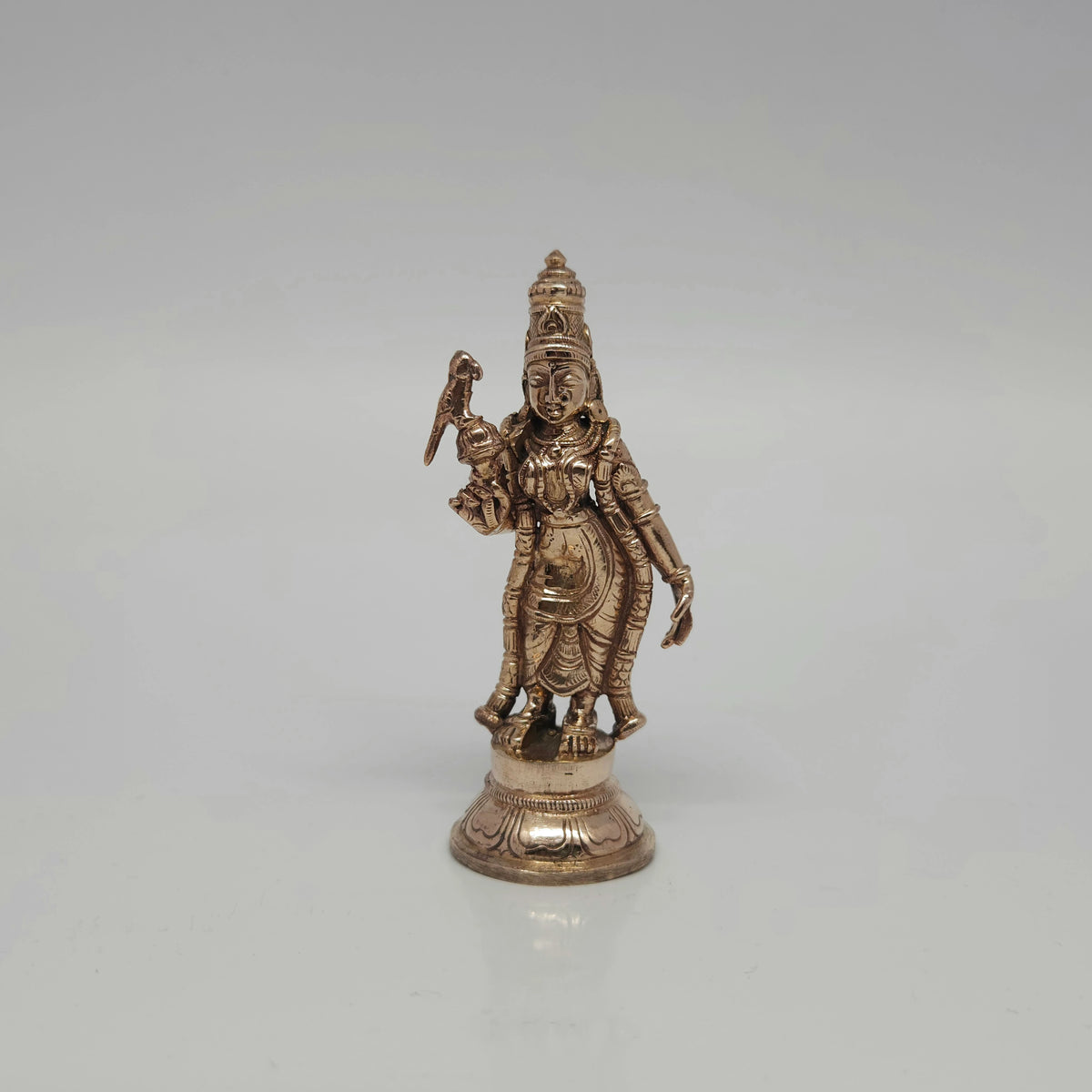 Straight front view of a 10cm handmade Swamimalai Panchaloha Madurai Meenakshi statue showing her holding a perfectly carved parrot by Sri Swaminathan and Co.