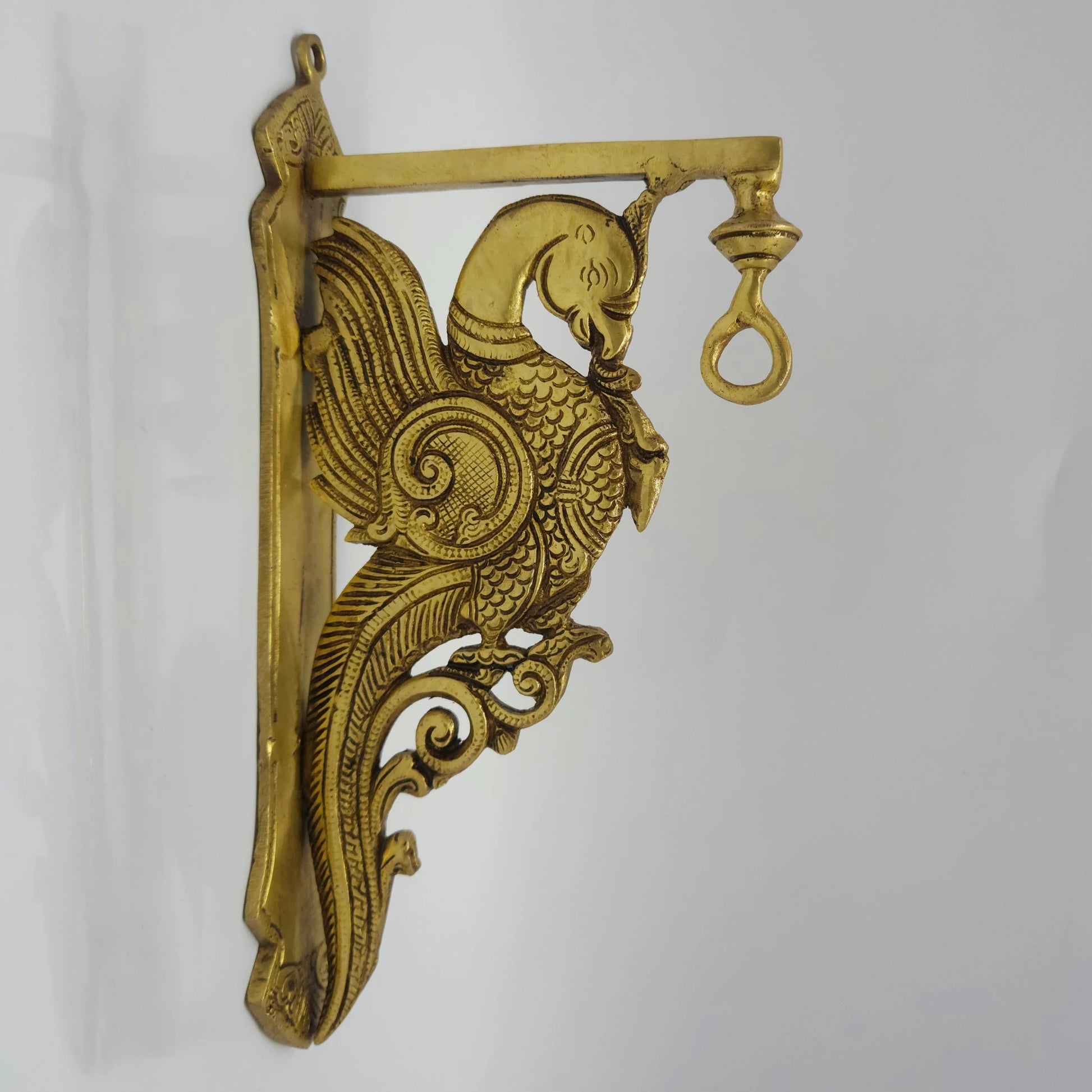 Side view of a 31cm heavy brass peacock wall stand bracket with a parrot design profile facing right by Sri Swaminathan and Co.