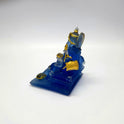 Top left perspective view of the frosted blue resin Ganesha murti showcasing the gold paint highlights on his crown and ornaments.