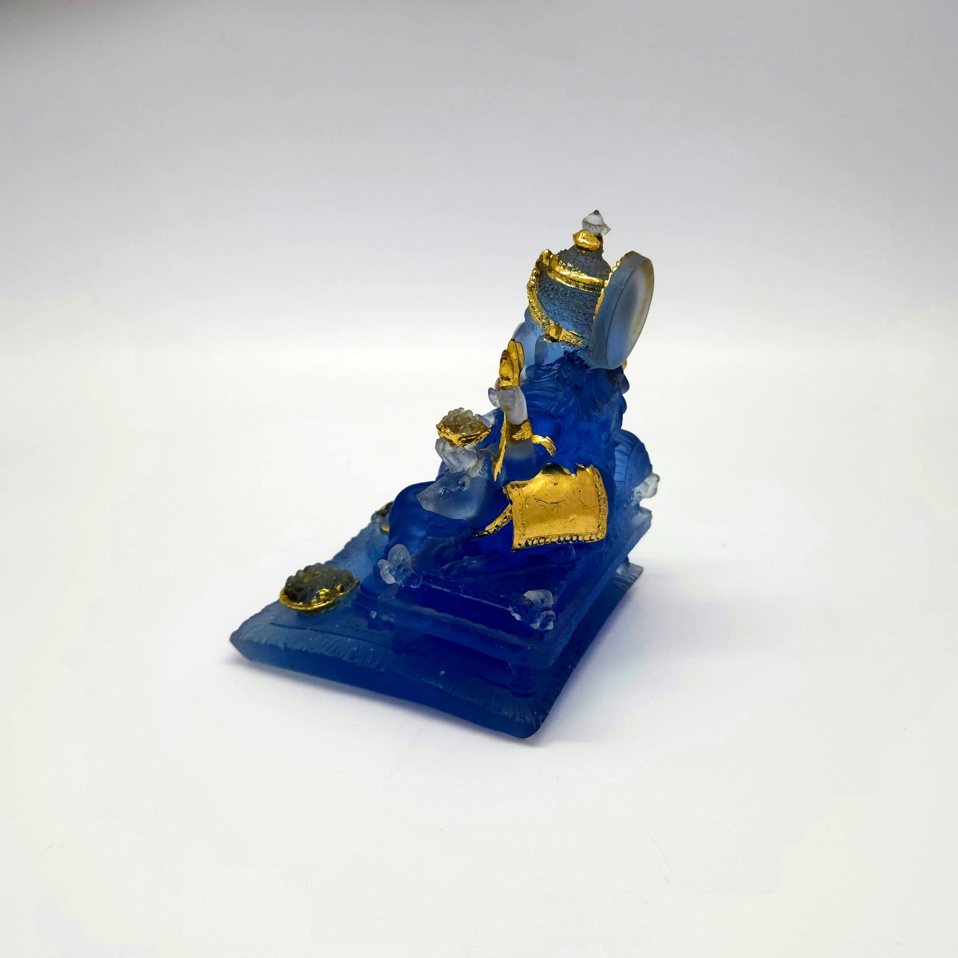 Top left perspective view of the frosted blue resin Ganesha murti showcasing the gold paint highlights on his crown and ornaments.