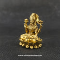  Three-quarter front right perspective view of the two and a half inch brass Lakshmi statue in her real form showcasing the beautifully chiseled lotus buds held in her upper hands.
