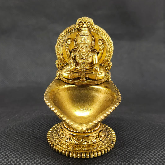  Direct straight back view of the two and a half inch solid brass Lakshmi vilakku lamp demonstrating the smooth rear surface of the sunburst halo crown backplate.

