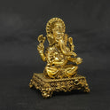 Forty five degree angle front right perspective view of the two and a half inch brass Ganesha statue highlighting his prominent fat abdomen and Mooshika on the corner.