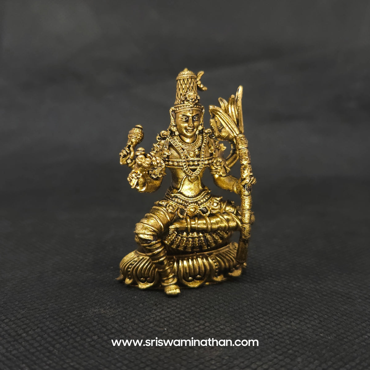 Three-quarter front right perspective view of the two and a half inch brass seated Lalitha Tripura Sundari statue showcasing the detailed crown and her sacred weapons.