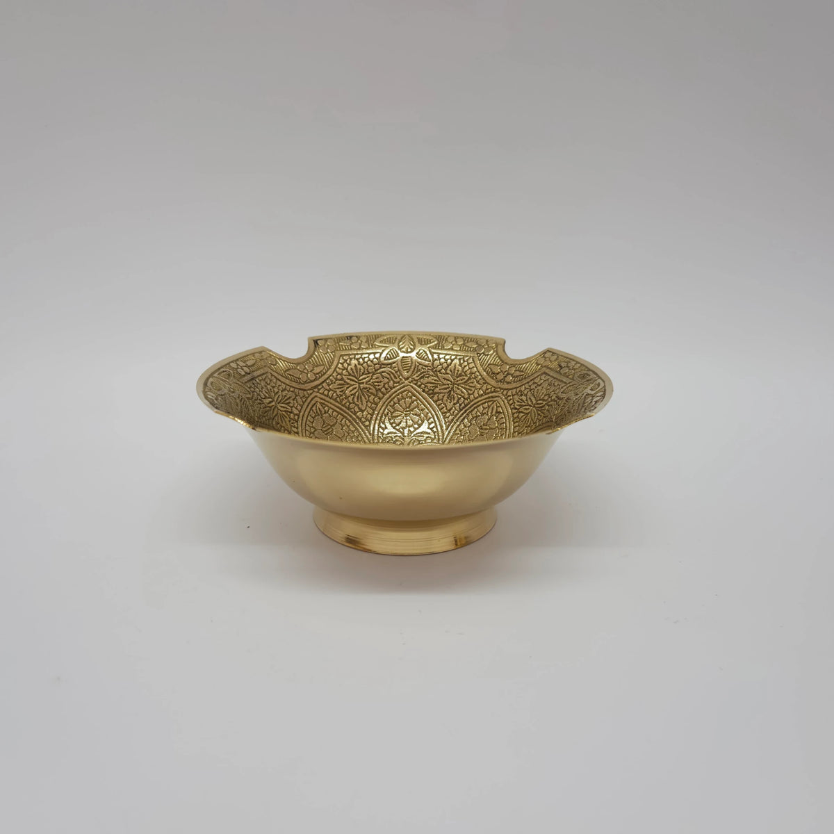 Straight front view of a single 12.5cm intricate floral engraved scalloped brass bowl showcasing its steady pedestal foot base by Sri Swaminathan and Co.
