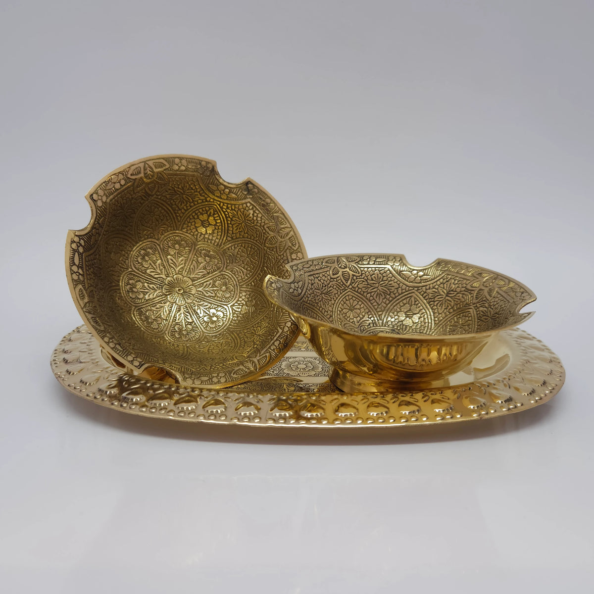 Arranged presentation view displaying two 12.5cm floral engraved brass bowls on a decorative serving tray highlighting the inner mandala patterns and scalloped loop rim.