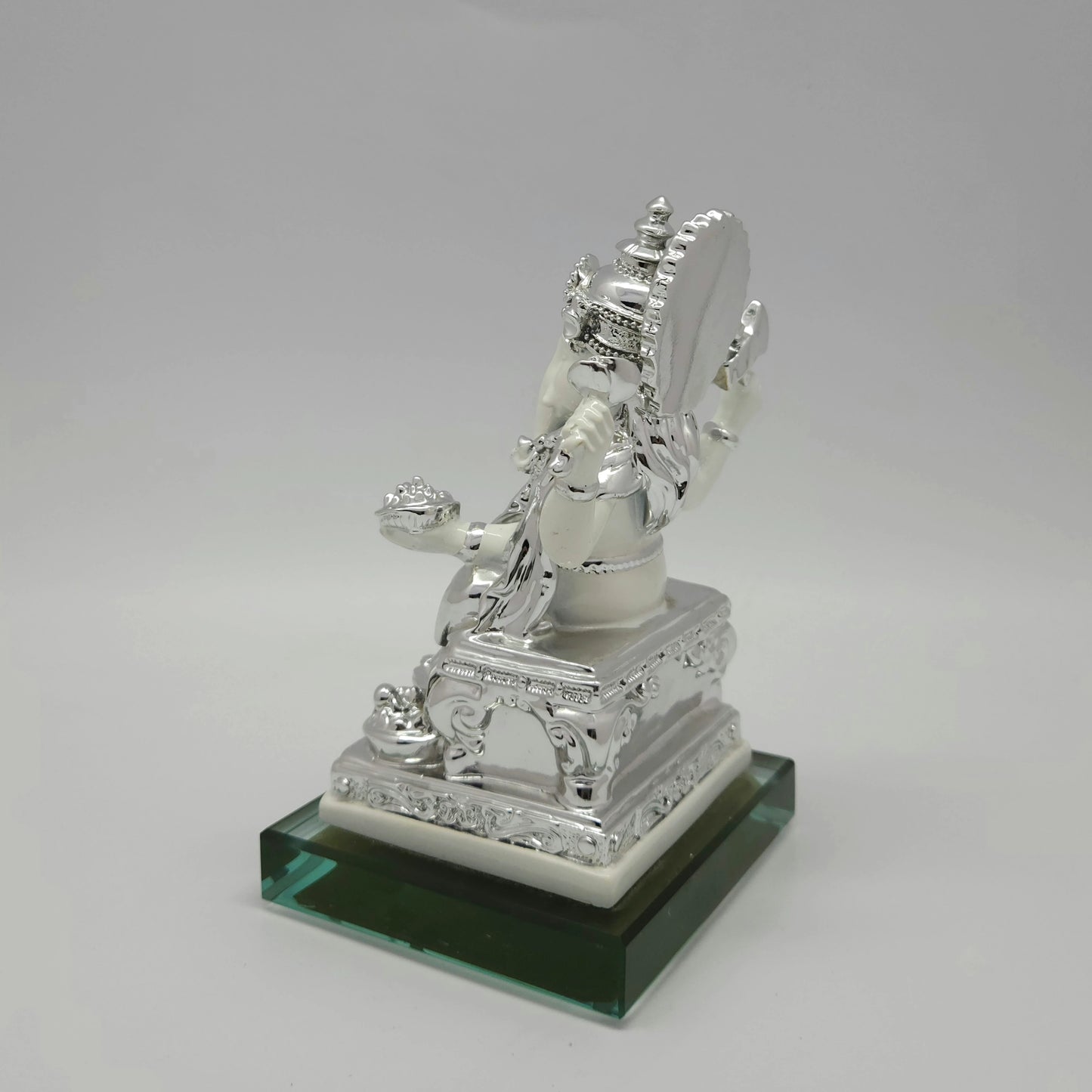 Right side view of the 6.9 inch silver paint resin Ganesha figurine displaying the elegant thickness of the ornate throne back halo.