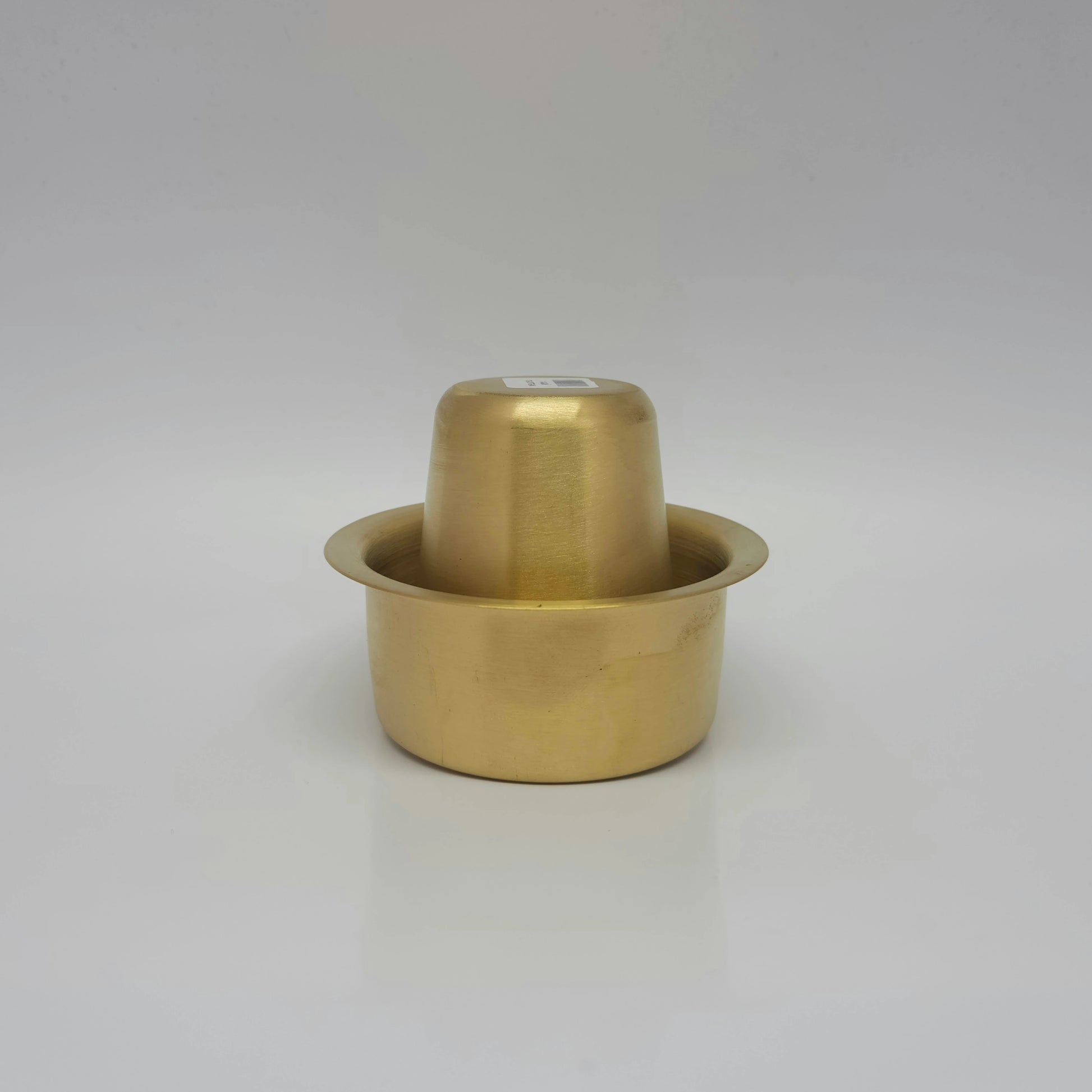 Assembled view showing the matte finish brass filter coffee tumbler placed upside down inside the davara basin for clean kitchen storage.
