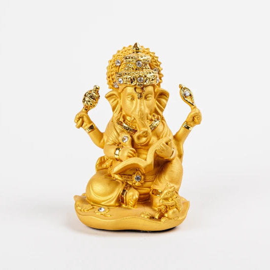 Small 9.5cm shiny metallic gold resin Ganesha idol sitting down and reading an open book with stone-studded crown by Sri Swaminathan and Co