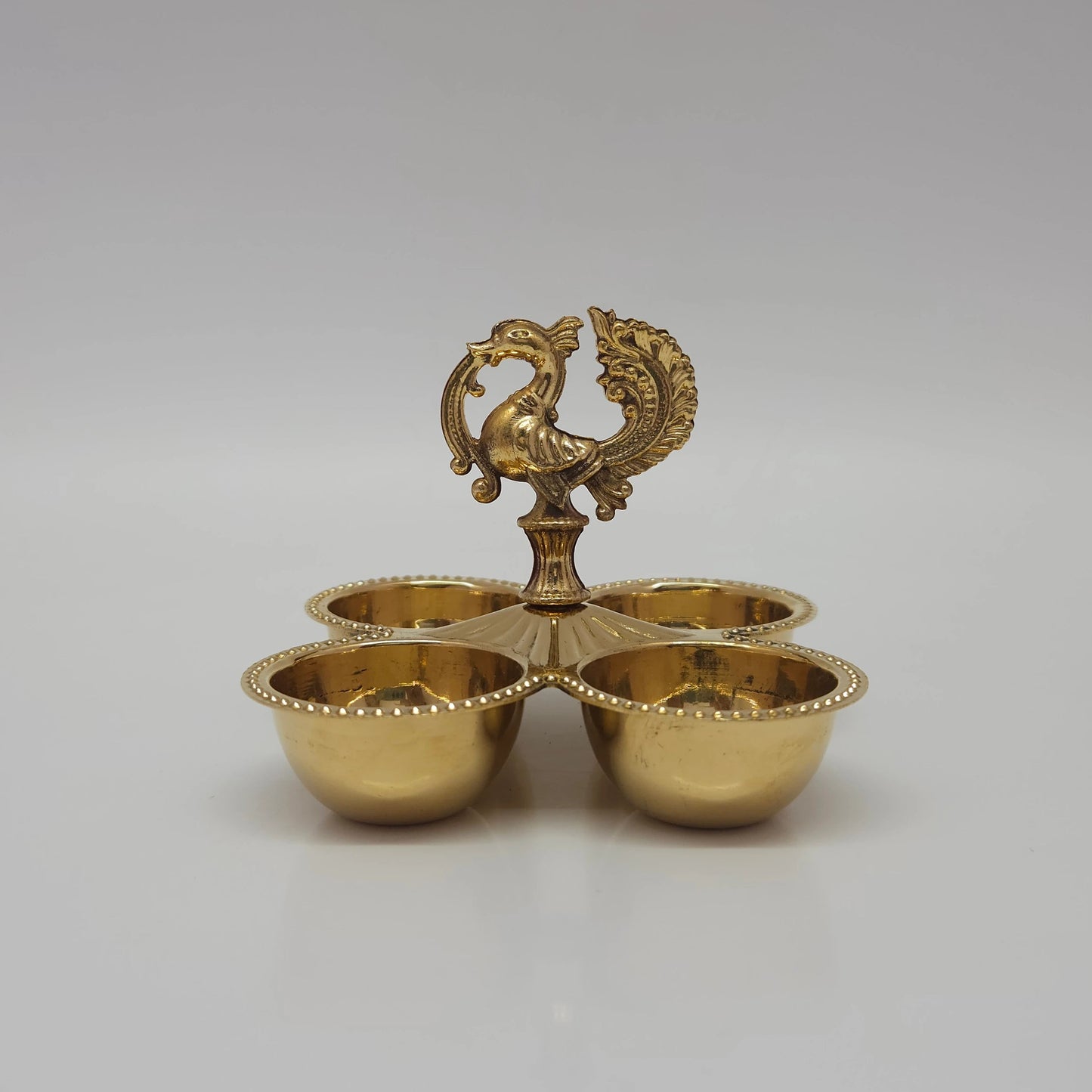 Front view look of the multi-purpose pure brass peacock stand with four deep cups.