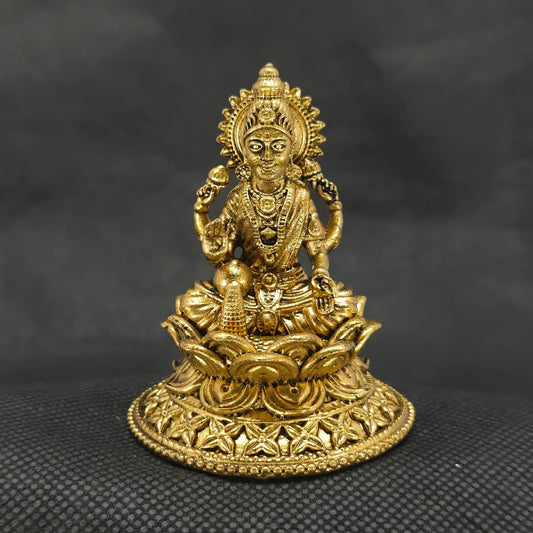 Straight front view of the premium solid brass Aishwarya Lakshmi statue showing the goddess seated on a circular lotus base pouring gold coins from a pot by Sri Swaminathan and Co.