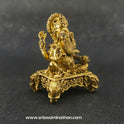 Three-quarter front left perspective view of the brass Ganesha statue on an elephant peedam highlighting the chiseled lines of his upper weapons and the deep three-dimensional thickness of the casting.
