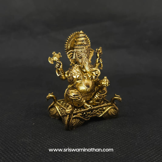 Three-quarter left side view of the solid brass Ganesha statue on a hamsa peedam showcasing the deep three-dimensional thickness of the casting and traditional weapon attributes.