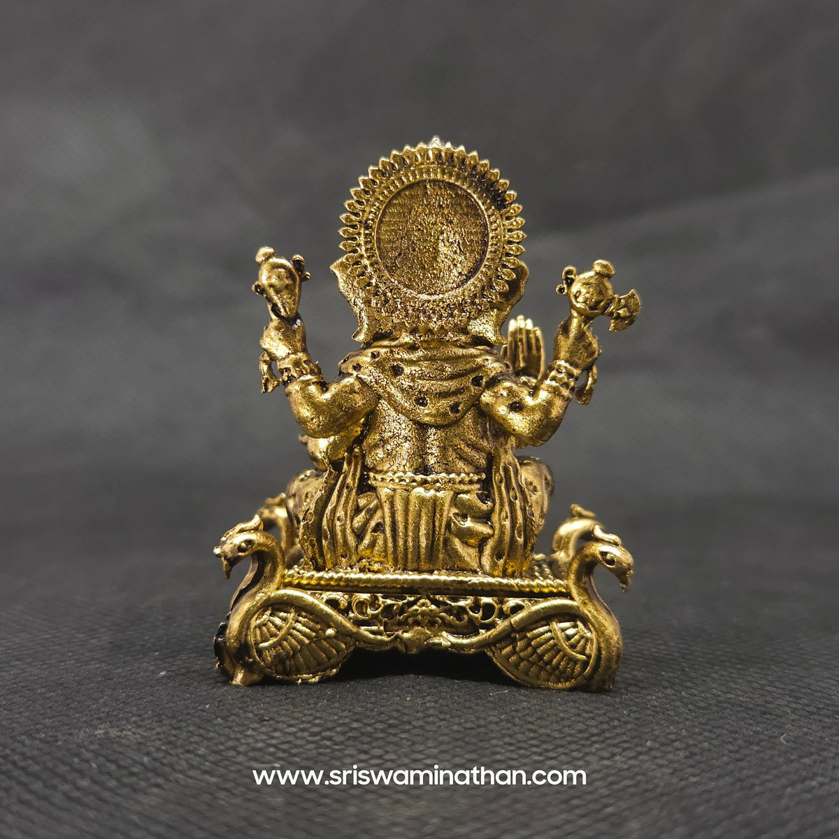 Direct straight back view of the solid brass Ganesha statue highlighting the reverse details of the sunburst halo crown and the rough hard-faced hamsa birds on the throne base.