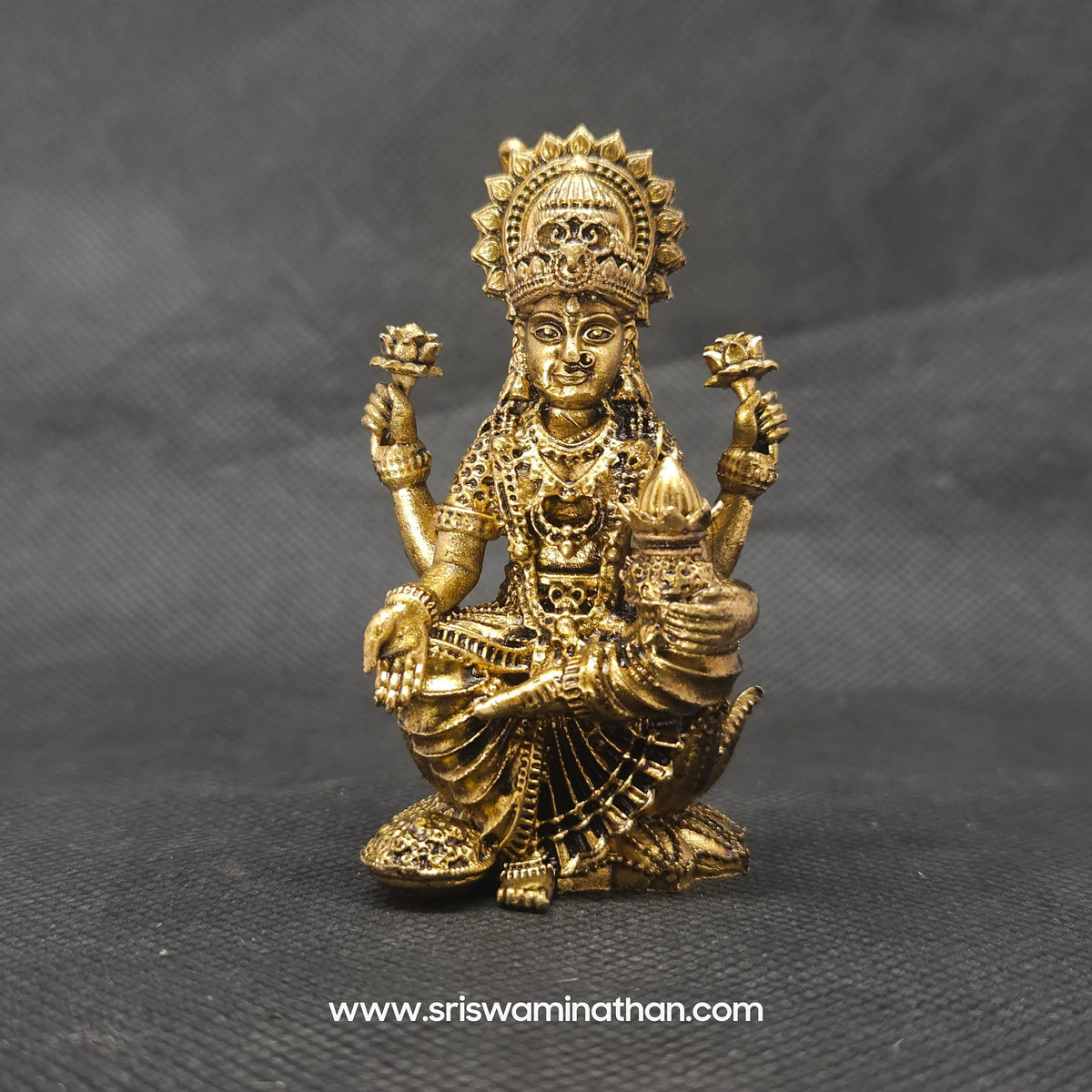 Straight front view of the premium solid brass Kubera Lakshmi statue showing the goddess seated next to a giant layered wealth pot by Sri Swaminathan and Co