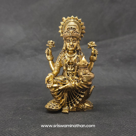Straight front view of the premium solid brass Kubera Lakshmi statue showing the goddess seated next to a giant layered wealth pot by Sri Swaminathan and Co