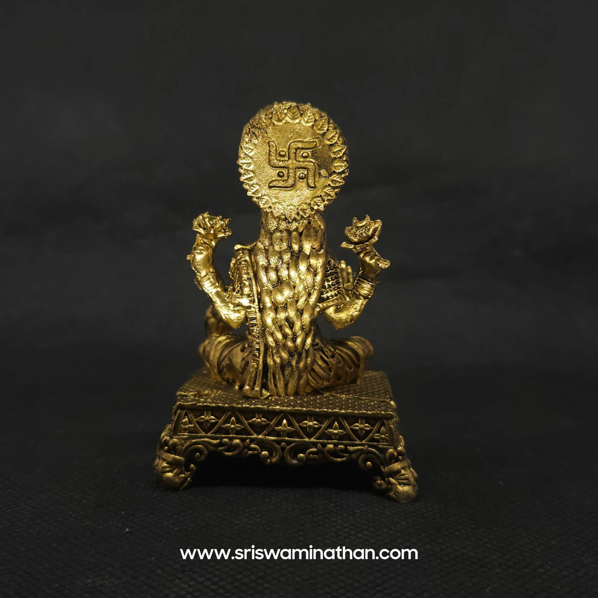 Direct straight back view of the solid brass Lakshmi statue demonstrating the detailed rear surface of the sunburst halo crown and back hair arrangement over the rectangular throne.