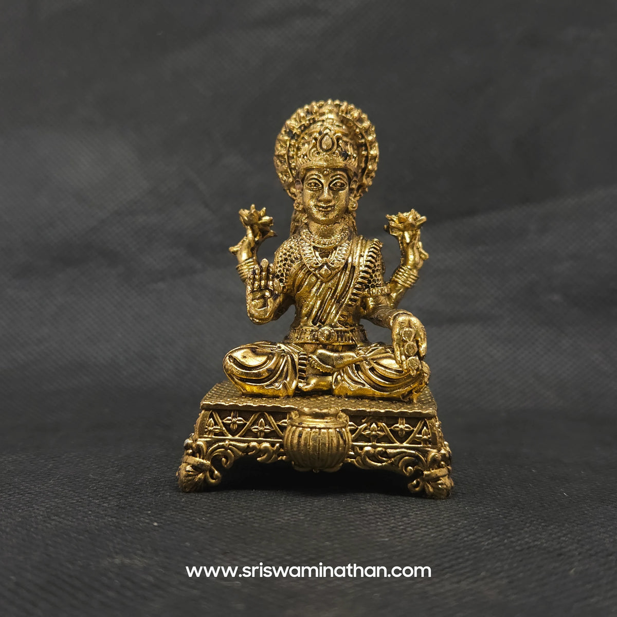 Straight front view of the premium solid brass Lakshmi statue showing the goddess seated in Padmasana on a flower decorated base with an Akshaya Patra vessel by Sri Swaminathan and Co