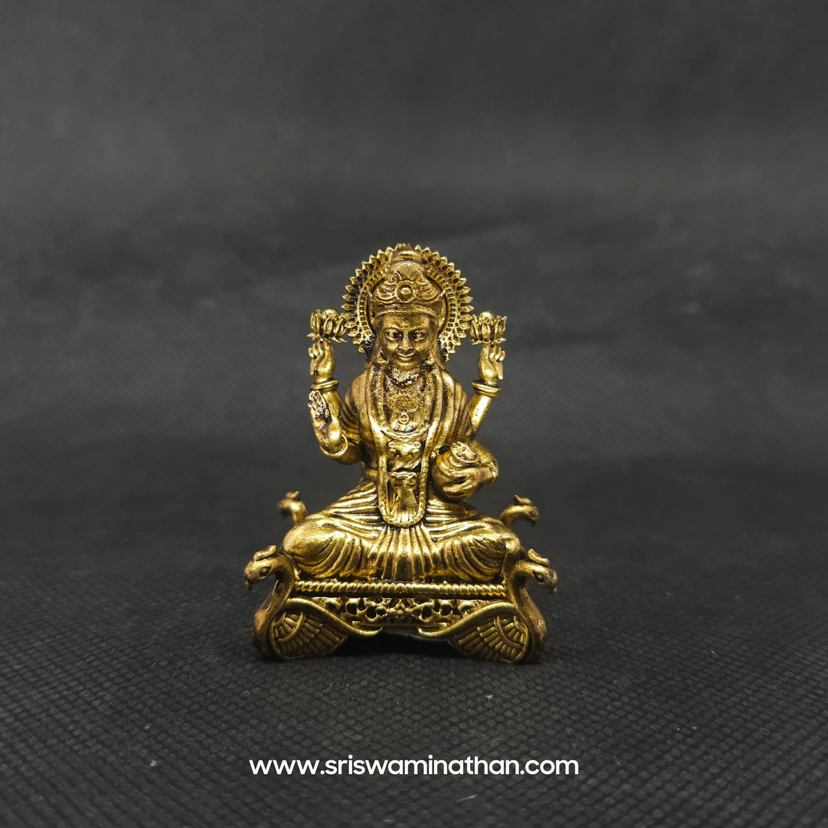 Straight front view of the premium solid brass Lakshmi statue showing the goddess seated in Padmasana on a four hamsa throne base by Sri Swaminathan and Co.