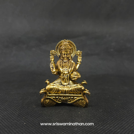 Straight front view of the premium solid brass Lakshmi statue showing the goddess seated in Padmasana on a four hamsa throne base by Sri Swaminathan and Co.