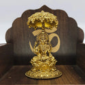 Straight front view of the premium solid brass Lakshmi statue showing the goddess seated on a round lotus peedam under a chiseled Kudai umbrella canopy by Sri Swaminathan and Co.
