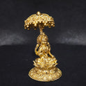 Three-quarter front left perspective view of the solid brass Lakshmi statue with a royal canopy highlighting the chiseled umbrella stem and the deep thickness of the solid casting.