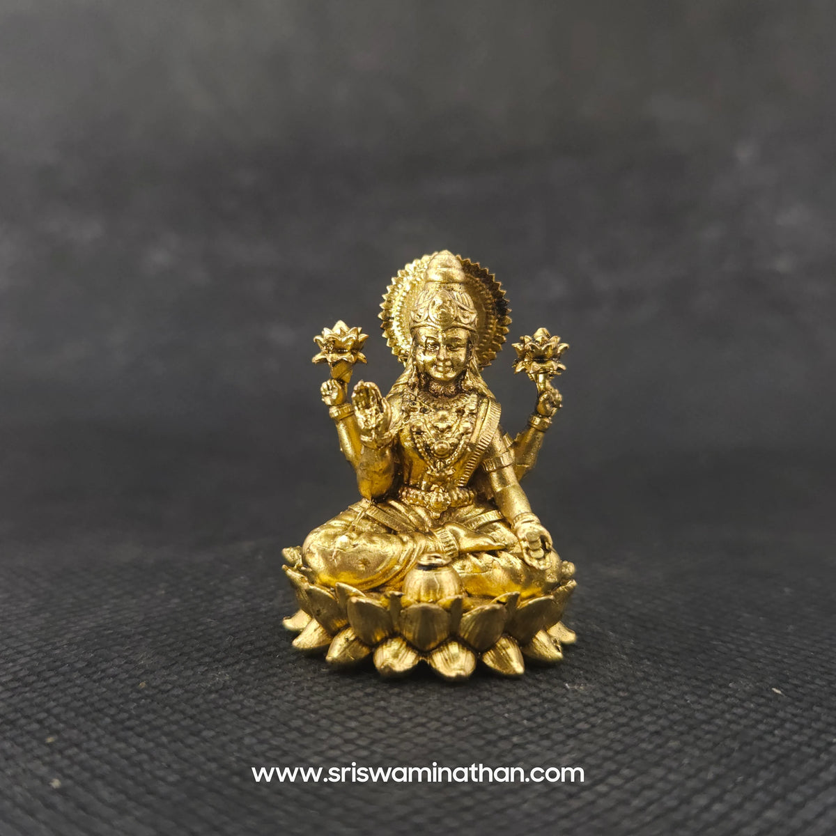 Straight front view of the premium solid brass Lakshmi statue showing the goddess in her actual real form seated in Padmasana on a double-bloomed round lotus peedam by Sri Swaminathan and Co.