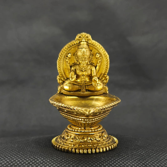 Straight front view of the premium solid brass Lakshmi vilakku deepam lamp showing the goddess on the backplate of the oil reservoir by Sri Swaminathan and Co.
