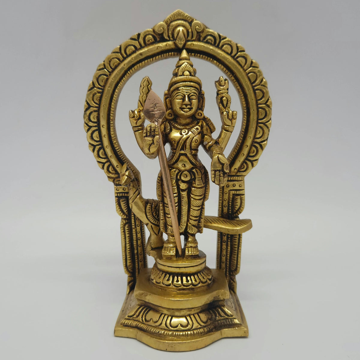 Direct straight front view of the premium solid brass Lord Murugan statue inside an ornate circular Prabhavali archway by Sri Swaminathan and Co.
